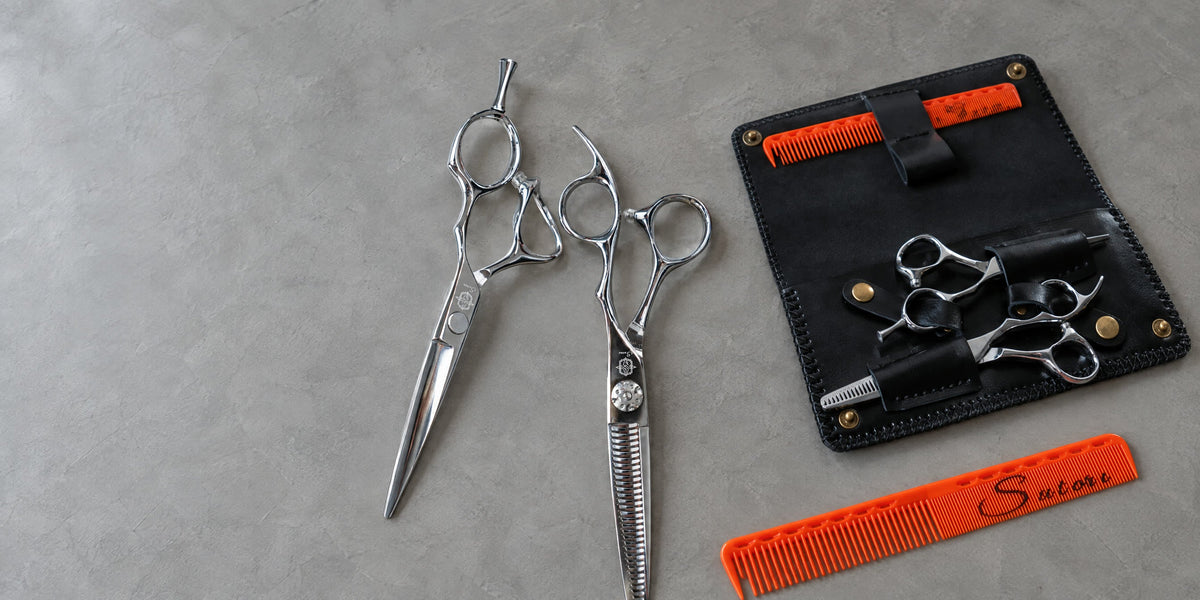 Sutori scissors, double leather case and cutting comb on grey microcement