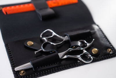 Sutori double leather case, open with two pairs of scissors and a comb