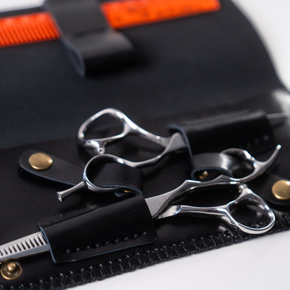 Sutori double leather case holding two pairs of scissors and a comb